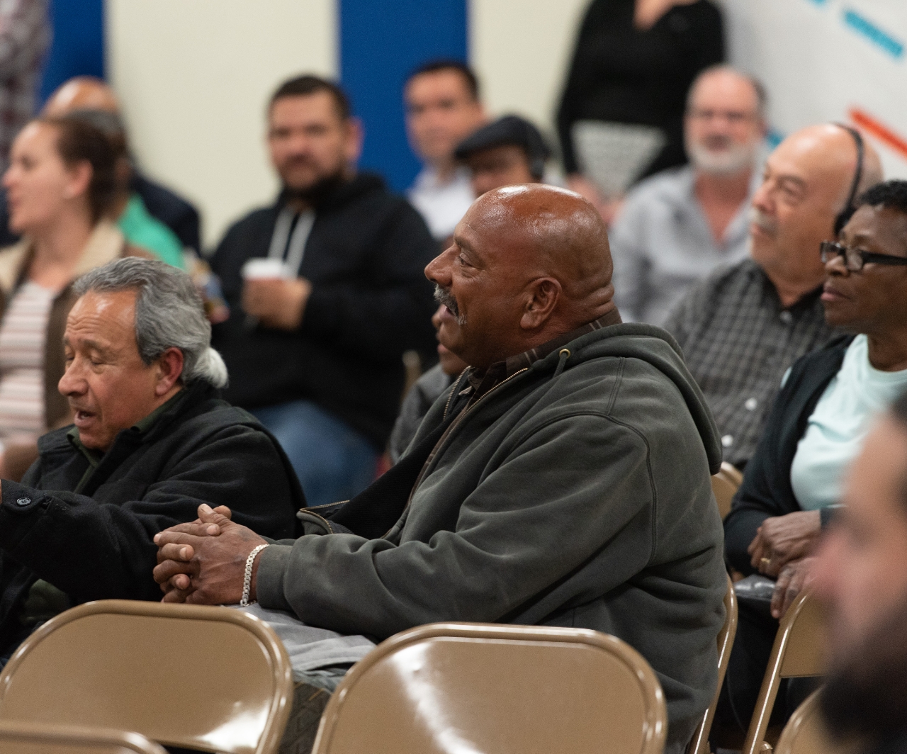 A group of people of different races and ethnicities attending a community meeting